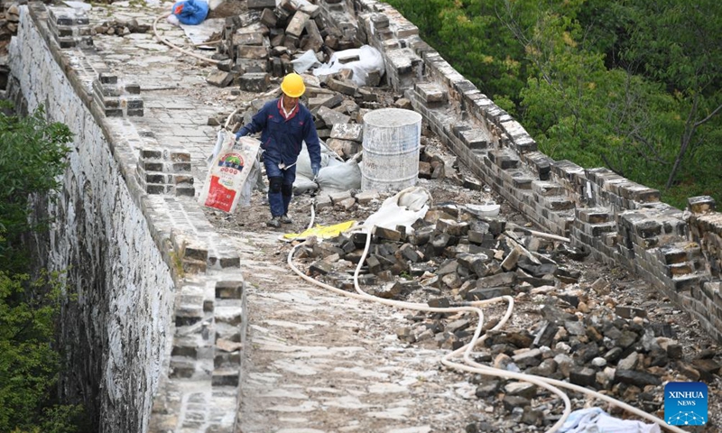 A worker walks on the Jiankou section of the Great Wall in Beijing, capital of China, July 2, 2024. Covering six defense towers, from No. 117 to No. 122, the fifth phase of the Jiankou section of the Great Wall repair project has progressed smoothly. Beijing has pioneered Great Wall archaeological research, which precedes the repair work. The Jiankou section and the Dazhuangke section in Yanqing District have been selected as pilot projects to promote research-oriented restoration and protection of the Great Wall. Photo: Xinhua