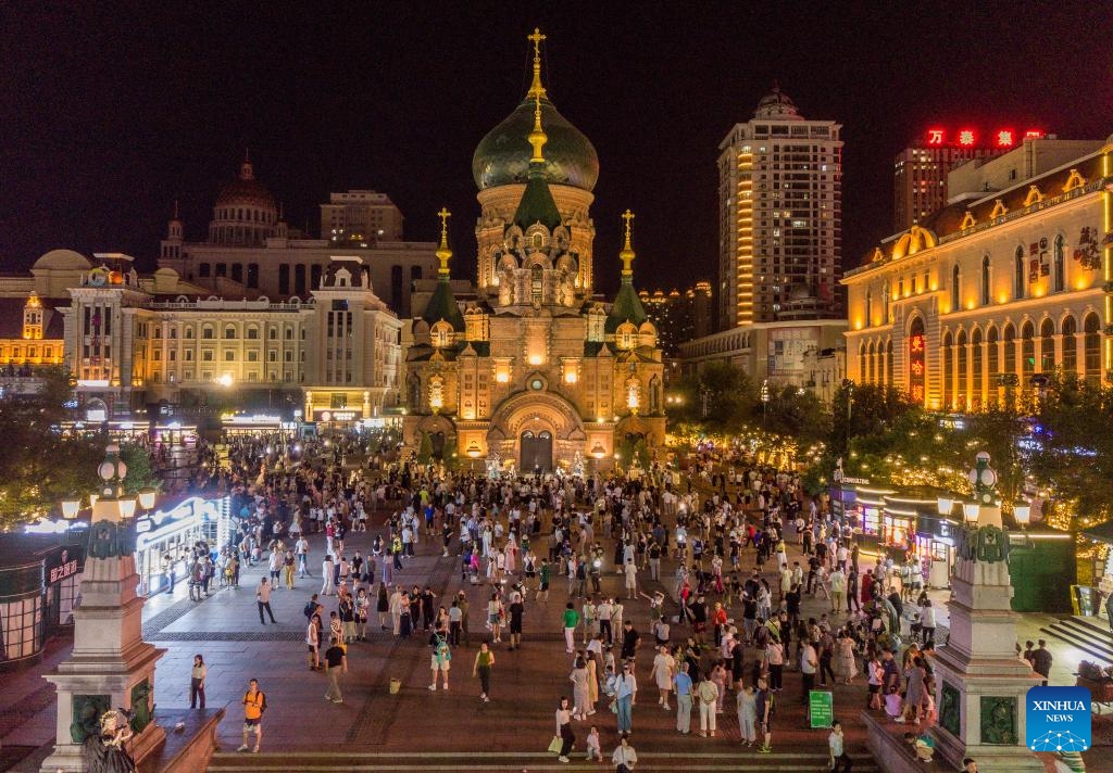 An aerial drone photo taken on Aug. 14, 2024 shows tourists visiting an art square in Harbin, northeast China's Heilongjiang Province. Known as China's Ice City, Harbin has a reputation for its cool weather and diversified attractions, even during the summer months, which helps it remain attractive to tourists throughout the year. (Photo: Xinhua)