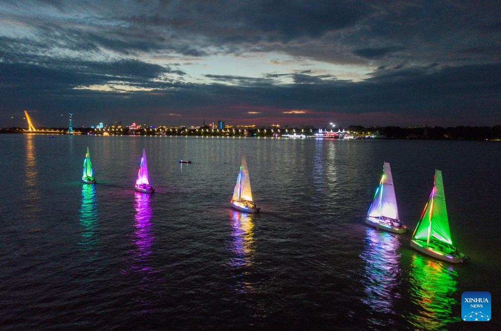 An aerial drone photo taken on Aug. 14, 2024 shows a sailing boat light show on the Harbin section of the Songhua River in Harbin, northeast China's Heilongjiang Province. Known as China's Ice City, Harbin has a reputation for its cool weather and diversified attractions, even during the summer months, which helps it remain attractive to tourists throughout the year. (Photo: Xinhua)