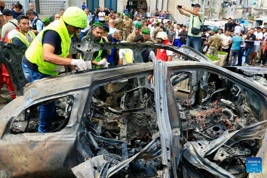 People check a vehicle destroyed by missiles from an Israeli drone in Sidon, Lebanon, on Aug. 21, 2024. An Israeli drone fired two air-to-surface missiles at a civilian SUV at the southern entrance to the city of Sidon on Wednesday morning, killing a leader in the Al-Aqsa Martyrs Brigades, the armed wing of the Palestinian National Liberation Movement (Fatah), Lebanese military sources told Xinhua. (Photo: Xinhua)