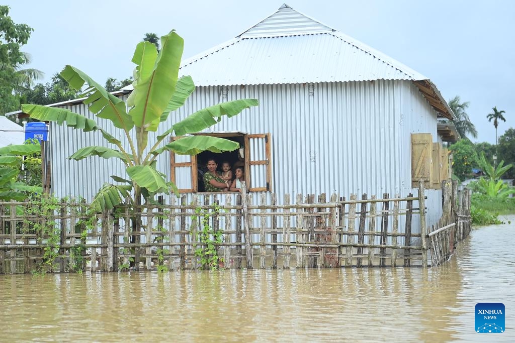 A family look out of a window of their hut in a flood-affected area on the outskirts of Agartala, the capital city of India's northeastern state of Tripura on Aug. 20, 2024. (Photo: Xinhua)