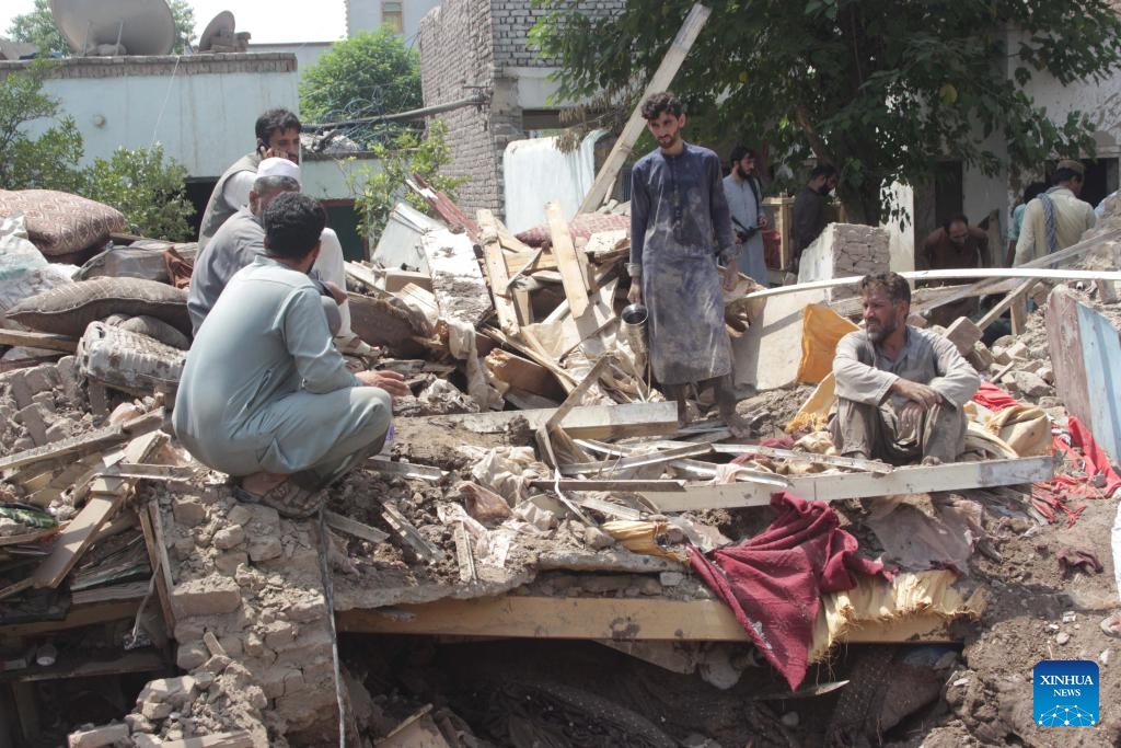 People are seen on the ruins in a flood-hit area in Jalalabad City, capital of Nangarhar province, east Afghanistan, Aug. 21, 2024. At least one person has been confirmed dead and seven others sustained injuries as a flash flood swept through parts of eastern Afghanistan's Nangarhar province on Tuesday night, provincial Director for Information and Culture Qurishi Badlon said Wednesday. (Photo: Xinhua)