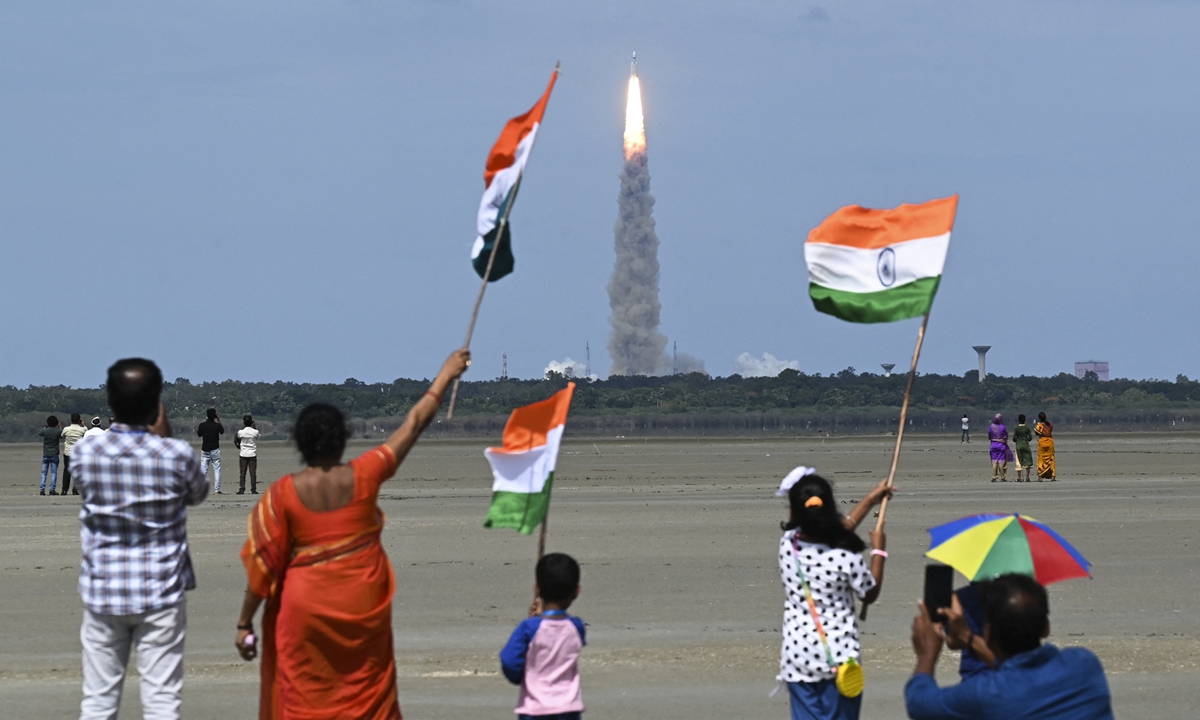 People wave Indian flags as an Indian Space Research Organisation (ISRO) rocket carrying the Chandrayaan-3 spacecraft lifts off from the Satish Dhawan Space Centre in Sriharikota, an island off the coast of southern Andhra Pradesh state on July 14, 2023. Photo: AFP