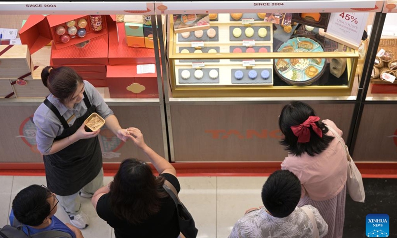 People taste mooncakes ahead of the Mid-Autumn Festival which falls on Sept. 17 this year, at a shopping mall in Singapore, Aug. 24, 2024. (Photo by Then Chih Wey/Xinhua)