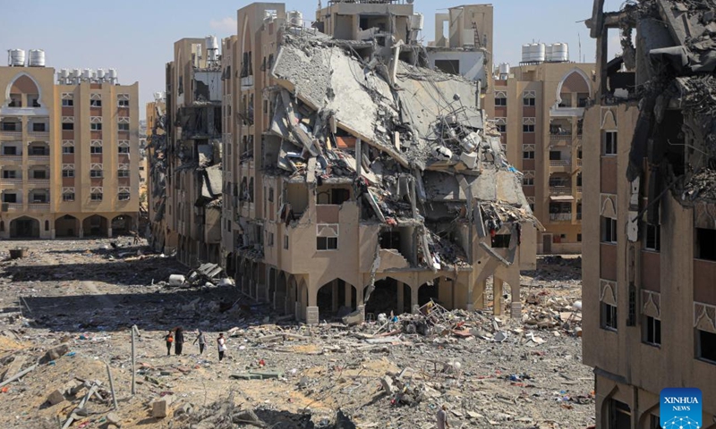 Palestinians check residential buildings destroyed by Israeli warplanes at the Hamad City, in the southern Gaza Strip city of Khan Younis, on Aug. 24, 2024. (Photo by Rizek Abdeljawad/Xinhua)