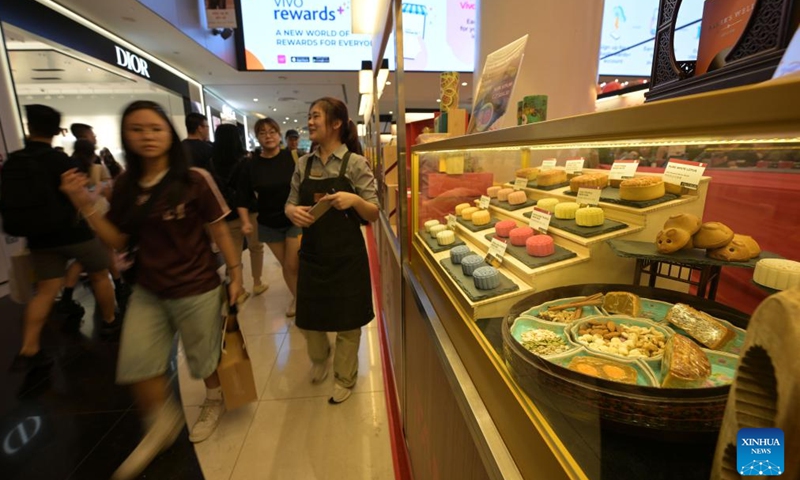 People walk past a booth of mooncakes ahead of the Mid-Autumn Festival which falls on Sept. 17 this year, at a shopping mall in Singapore, Aug. 24, 2024. (Photo by Then Chih Wey/Xinhua)