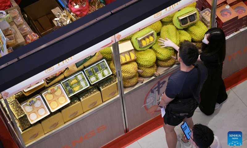 People select durian-flavored mooncakes ahead of the Mid-Autumn Festival which falls on Sept. 17 this year, at a shopping mall in Singapore, Aug. 24, 2024. (Photo by Then Chih Wey/Xinhua)