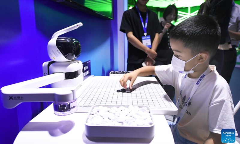 A boy plays chess with a robot at the exhibition area of HICOOL 2024 Global Entrepreneur Summit in Beijing, capital of China, Aug. 24, 2024. The global entrepreneur summit was held in Beijing from Friday to Sunday. (Xinhua/Ren Chao)