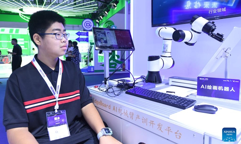 A visitor experiences robot painting at the exhibition area of HICOOL 2024 Global Entrepreneur Summit in Beijing, capital of China, Aug. 24, 2024. The global entrepreneur summit was held in Beijing from Friday to Sunday. (Xinhua/Ren Chao)