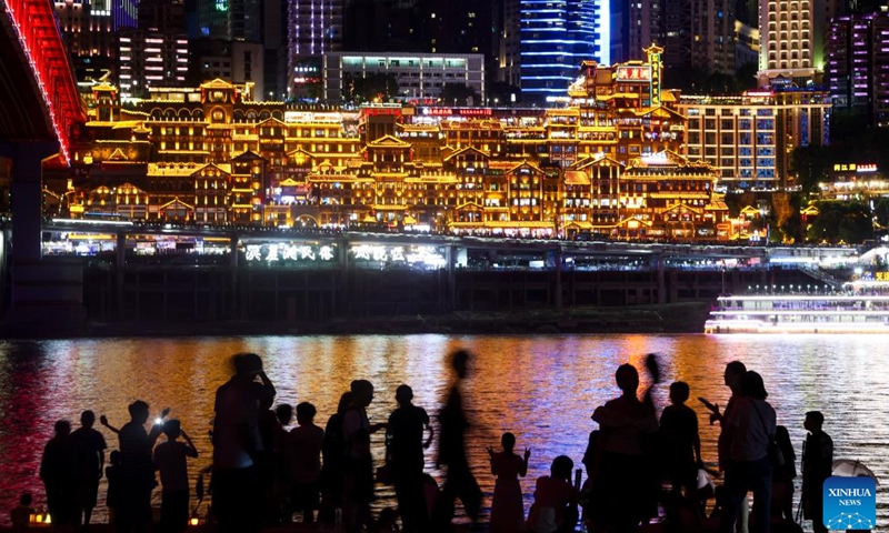 Tourists visit the Hongyadong scenic spot at night in Chongqing, southwest China, Aug. 23, 2024. Renowned tourist destinations in Chongqing, a city known for its high temperatures, attract many tourists in summer. (Xinhua/Liu Chan)