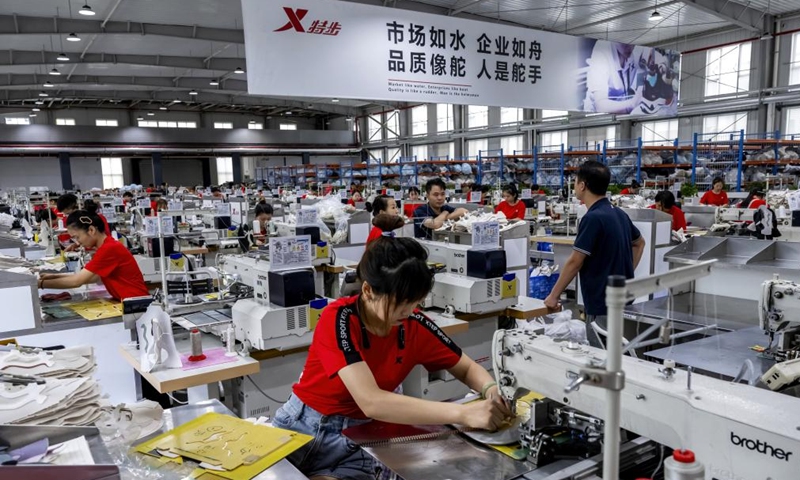 Staff members work on a production line at a workshop of China's sportswear giant Xtep in Jinjiang, southeast China's Fujian Province, Aug. 22, 2024. Jinjiang, a county-level city covering a total area of 649 square kilometers, is home to some 96,000 private enterprises that contributed over 90 percent of the city's industrial output, tax revenue and job opportunities in 2023. (Xinhua/Wei Peiquan)