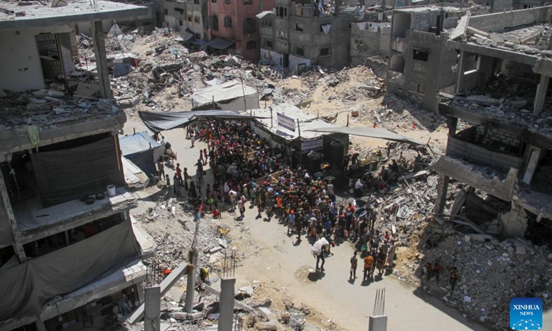 People gather to receive food relief in the Jabalia refugee camp in the northern Gaza Strip, on Aug. 26, 2024. The UN Office for the Coordination of Humanitarian Affairs (OCHA) said on Aug. 23 that humanitarian partners working to provide nutrition reported the number of children in northern Gaza who were diagnosed with acute malnutrition soared by over 300 percent last month compared to May -- and by more than 150 percent in the south. (Photo: Xinhua)