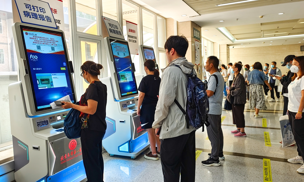 People queue to print examination reports on the self-service printing devices at the Peking University First Hospital in Beijing, on September 1, 2023. Photo: VCG