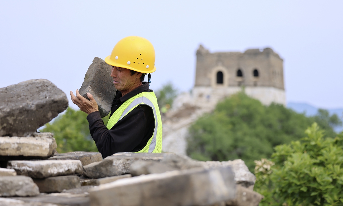 A worker carries a brick at the Jiankou section of the Great Wall in Beijing. Photo: IC