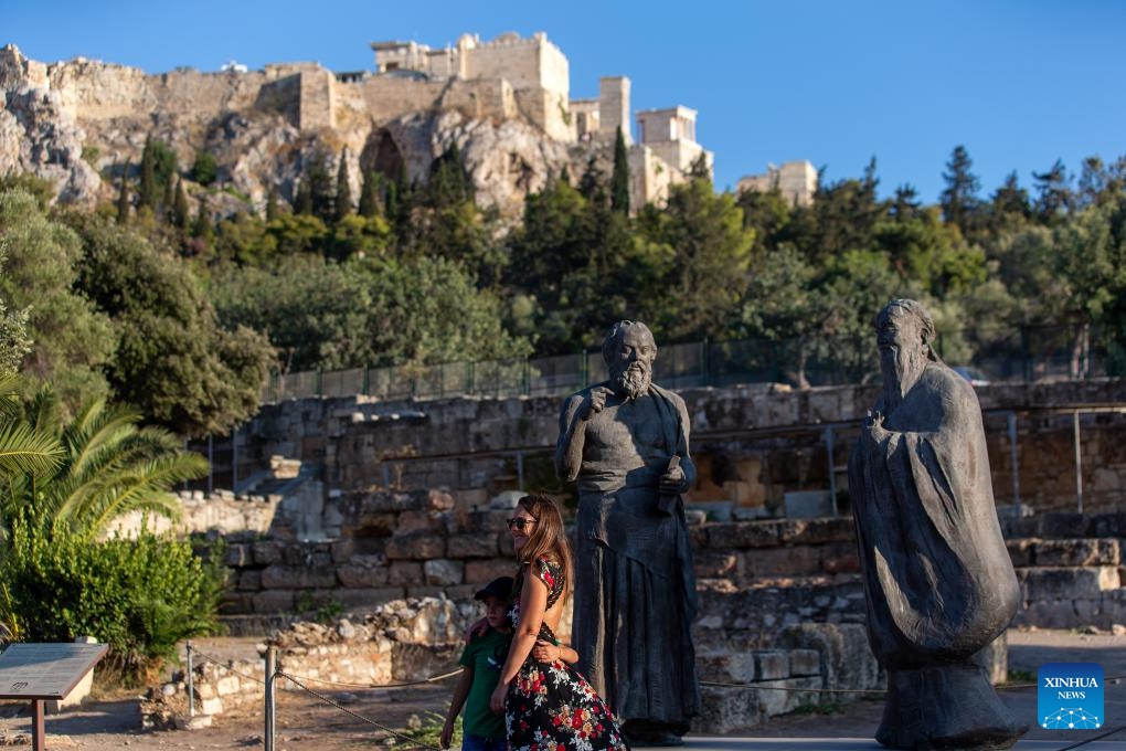 Tourists pose for a photo in front of statues of philosophers Socrates and Confucius at the ancient Agora of Athens in Athens, Greece, on Aug. 27, 2024. Greek tourism revenue surged by 12.2 percent in the first half of 2024 year-on-year to reach 6.921 billion euros (7.75 billion U.S. dollars), according to recent data from the Bank of Greece. (Photo: Xinhua)