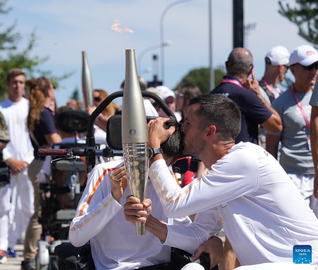 Torch bearer Valentin Francavilla (R) kisses his brother Theophile Francavilla during the Paris 2024 Paralympic Games Torch Relay in Fontainebleau, France, Aug. 27, 2024. (Photo: Xinhua)