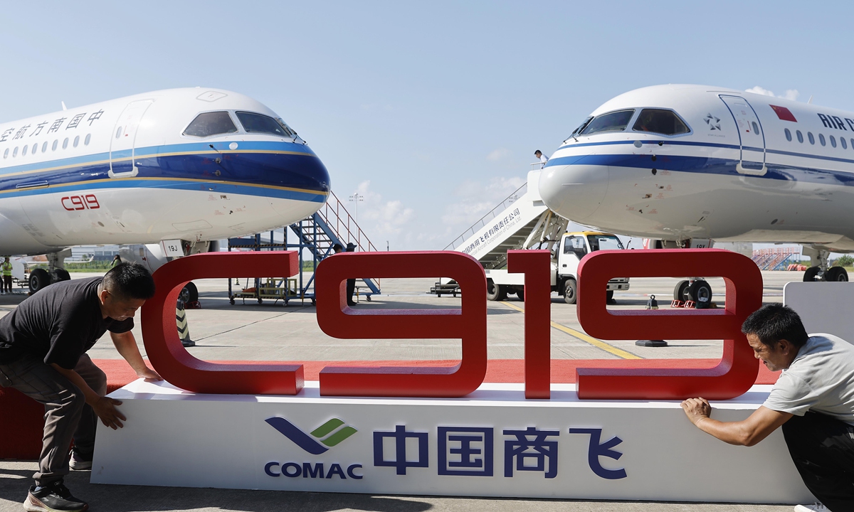 Two workers prepare for a delivery ceremony of the first C919 aircraft to each of two Chinese airlines, Air China - the country's flag carrier - and China Southern Airlines. The ceremony is held on August 28, 2024 in Shanghai, where the Commercial Aircraft Corporation of China (COMAC), the manufacturer of the C919, is headquartered. The latest deliveries marked a new phase of multi-user operation for the C919 jet. Photo: VCG