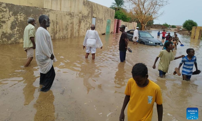 This photo taken with a mobile phone shows people wading through floodwater in Dongola, Sudan, Aug. 27, 2024. The death toll from heavy rains hitting so far 10 states in Sudan has reached 138, the country's Health Ministry said Tuesday. (Photo: Xinhua)