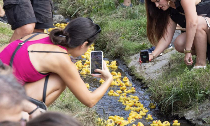 People take photos of rubber ducks during a rubber duck race, also a charity event, in Szentendre, Hungary, on Aug. 31, 2024. (Photo by Attila Volgyi/Xinhua)