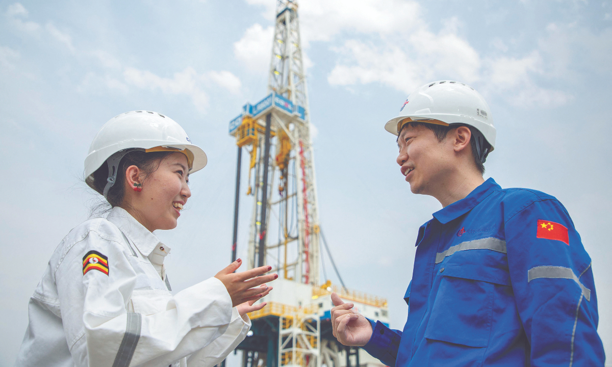 Chinese workers engange in work conversation at the Kingfisher oil field in Kikuube district, Uganda on January 24, 2023. Photo: VCG