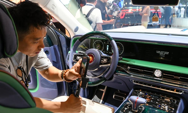 A visitor takes photos inside a Hongqi vehicle during Chengdu Motor Show 2024 in Chengdu, southwest China's Sichuan Province, Aug. 30, 2024. The Chengdu Motor Show 2024 kicked off here on Friday. Nearly 130 Chinese and foreign car companies made appearance during the motor show, with more than 1,600 vehicles on display. (Xinhua/Tang Wenhao)