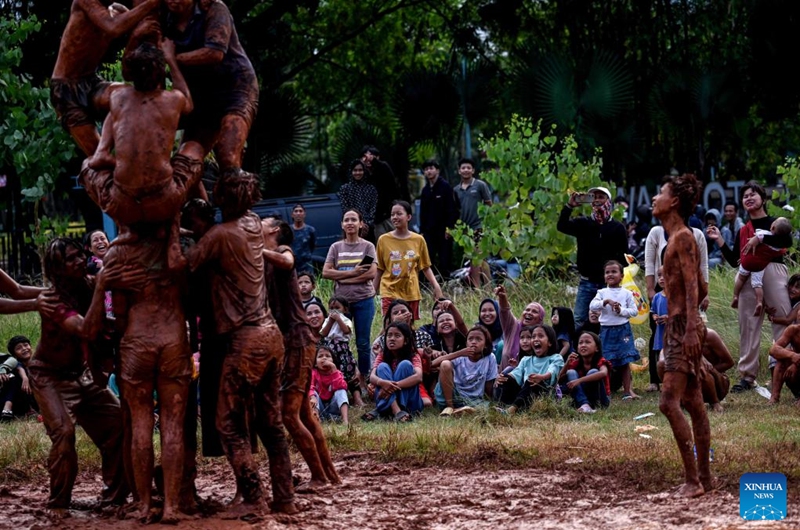 People laugh as they watch a greasy muddy pole climbing game in South Tangerang, Banten Province, Indonesia, Aug. 31, 2024. Photo: Xinhua