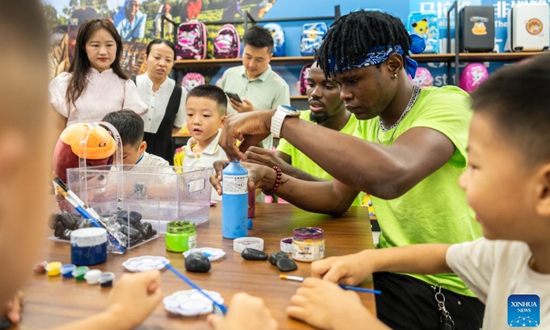 Volunteers introduce stone painting to children during a hands-on experience session at the Malawi pavilion of a permanent exhibition hall of the China-Africa Economic and Trade Cooperation Promotion Innovation Demonstration Park in Changsha, central China's Hunan Province, Aug. 30, 2024. Various activities promoting youth communication between China and Africa were organized here during the summer vacation. With the help of African volunteers from local universities, Chinese students were able to feel the charm of African culture by learning traditional African dance, music, folk arts, and making immersive tours of African customs via VR devices. Photo: Xinhua