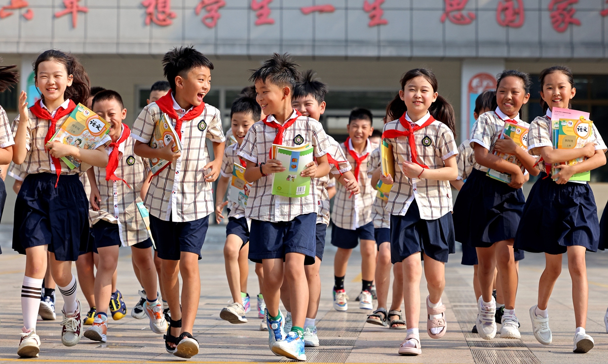 Students at a primary school in Zaozhuang, East China's Shandong Province, start the new semester while receiving their new textbooks on September 1, 2024. Photo: VCG