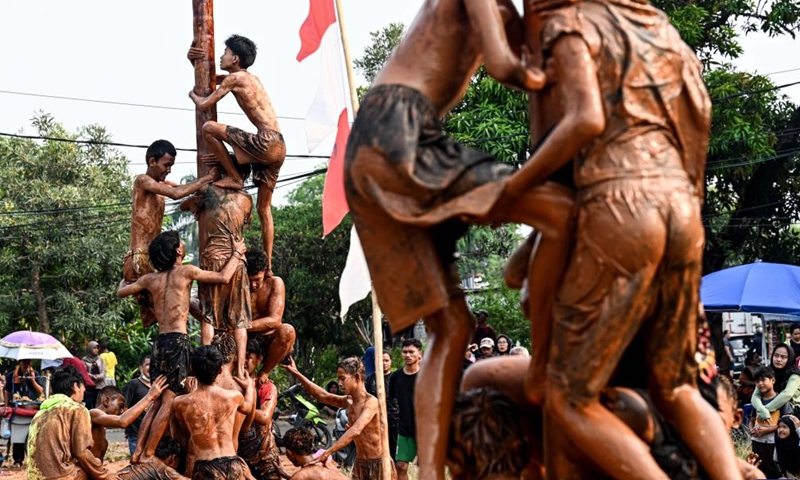 Children participate in a greasy muddy pole climbing game in South Tangerang, Banten Province, Indonesia, Aug. 31, 2024. Photo: Xinhua