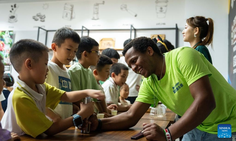 A volunteer grinds coffee beans with children during a hands-on experience session at the Ethiopia pavilion of a permanent exhibition hall of the China-Africa Economic and Trade Cooperation Promotion Innovation Demonstration Park in Changsha, central China's Hunan Province, Aug. 30, 2024. Various activities promoting youth communication between China and Africa were organized here during the summer vacation. With the help of African volunteers from local universities, Chinese students were able to feel the charm of African culture by learning traditional African dance, music, folk arts, and making immersive tours of African customs via VR devices. Photo: Xinhua