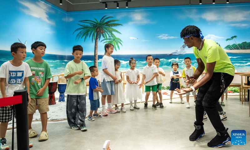 A volunteer teaches children African dance during a hands-on experience session at the Angola pavilion of a permanent exhibition hall of the China-Africa Economic and Trade Cooperation Promotion Innovation Demonstration Park in Changsha, central China's Hunan Province, Aug. 30, 2024. Various activities promoting youth communication between China and Africa were organized here during the summer vacation. With the help of African volunteers from local universities, Chinese students were able to feel the charm of African culture by learning traditional African dance, music, folk arts, and making immersive tours of African customs via VR devices. Photo: Xinhua