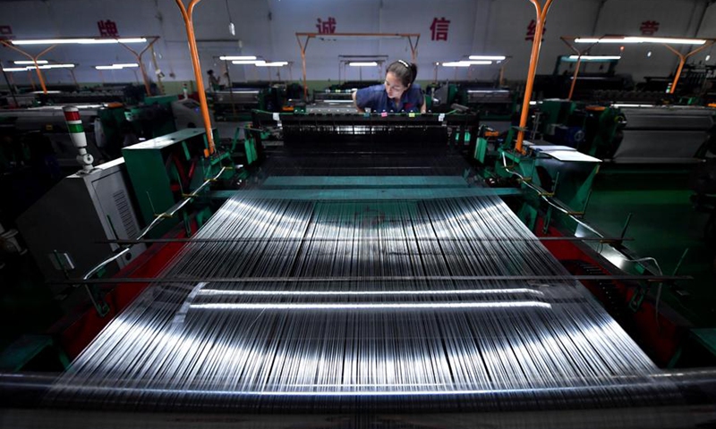 A staff member works at a production line of wire mesh at an enterprise in Anping, north China's Hebei Province, Aug. 30, 2024. Photo: Xinhua