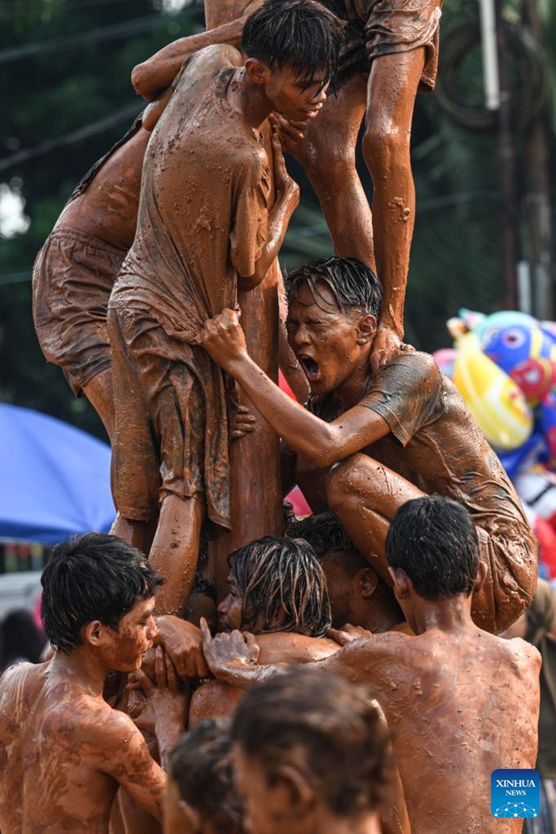 Children participate in a greasy muddy pole climbing game in South Tangerang, Banten Province, Indonesia, Aug. 31, 2024. Photo: Xinhua