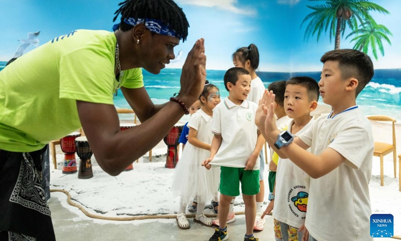 A boy gives a high five to a volunteer during a hands-on experience session at the Angola pavilion of a permanent exhibition hall of the China-Africa Economic and Trade Cooperation Promotion Innovation Demonstration Park in Changsha, central China's Hunan Province, Aug. 30, 2024. Various activities promoting youth communication between China and Africa were organized here during the summer vacation. With the help of African volunteers from local universities, Chinese students were able to feel the charm of African culture by learning traditional African dance, music, folk arts, and making immersive tours of African customs via VR devices. Photo: Xinhua