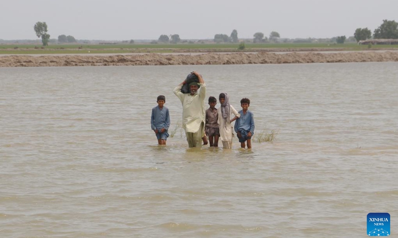 People cross flooded area in Dadu district of Pakistan's southern Sindh province, on Sept. 2, 2024. A total of 293 people have been killed and 564 others injured in monsoon rain-triggered accidents in Pakistan in the past two months as heavy downpours continued to wreak havoc in parts of the country, according to the National Disaster Management Authority. (Photo: Xinhua)