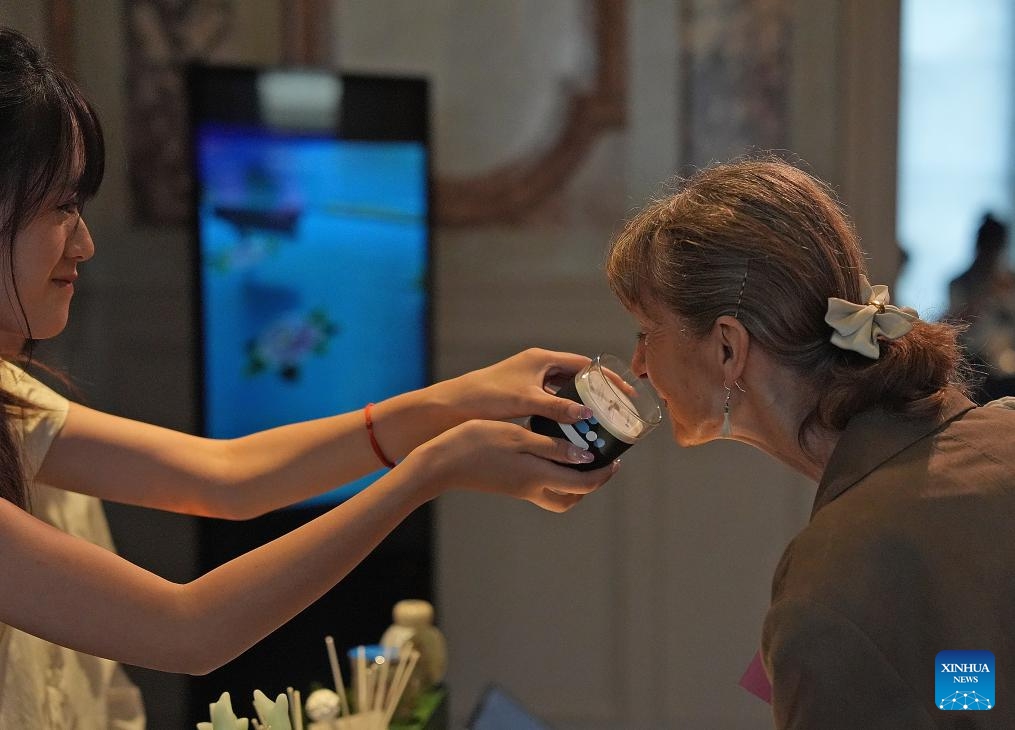 A woman tries an aromatic product during the Beautiful Crafts Workshop, Blossoming in Paris exhibition of cultural and creative works by women with disabilities at Chinese Cultural Center in Paris, France, Sept. 3, 2024. (Photo: Xinhua)