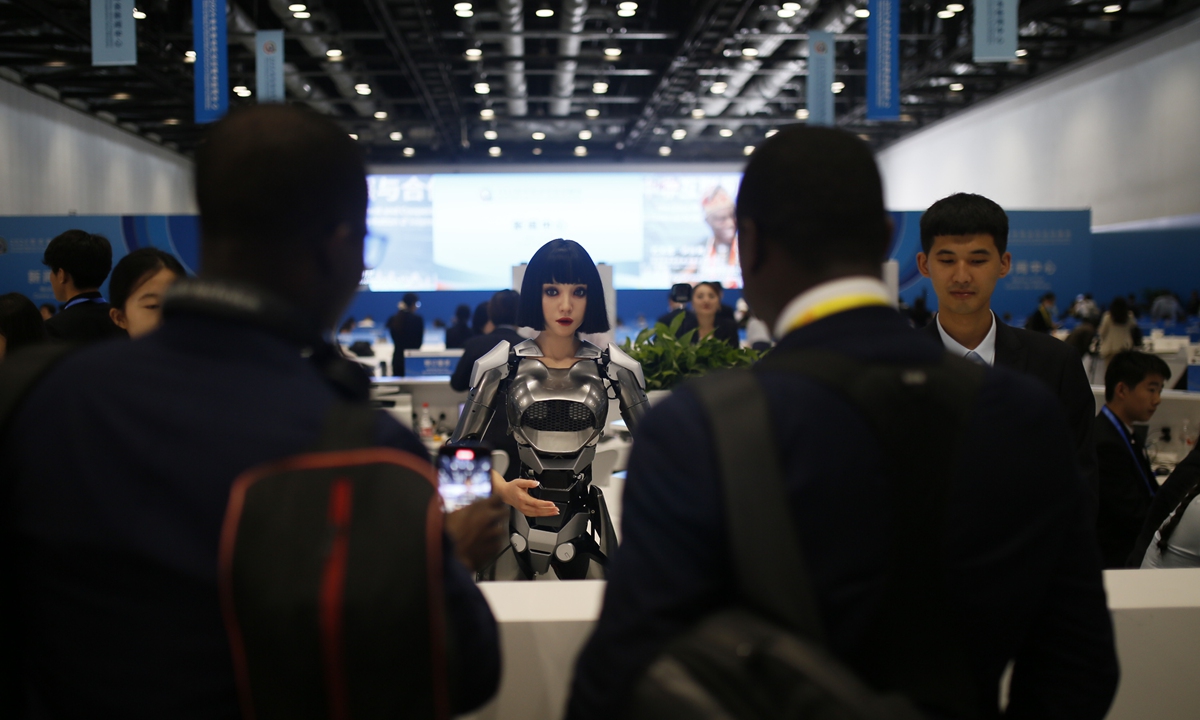 Two African journalists talk with AI robot Xiao Qi at the FOCAC Media Center on September 4, 2024. Photo: Shan Jie/GT