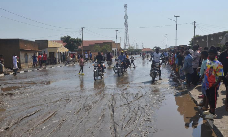 Residents ride on a waterlogged street in Kasese, western Uganda, Sept. 8, 2024. Three people were killed in flash floods triggered by heavy downpours Saturday in the western Ugandan district of Kasese, according to a humanitarian relief agency. (Photo by Gilbert Muhanguzi/Xinhua)