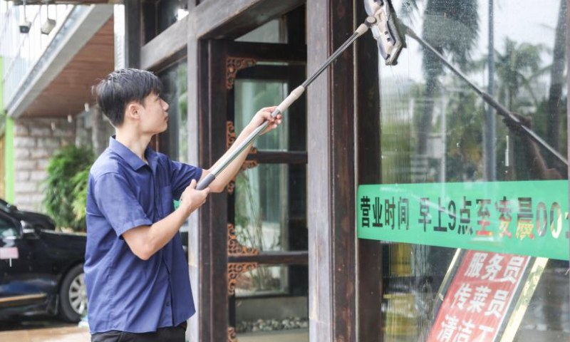 A man cleans the window of a restaurant in Haikou, south China's Hainan Province, Sept. 7, 2024. Yagi, the 11th typhoon of the year, made landfall in Hainan on Friday afternoon. As winds and rainfall subsided, Hainan downgraded its typhoon alert and initiated swift recovery operations across the province. (Xinhua/Zhang Liyun)