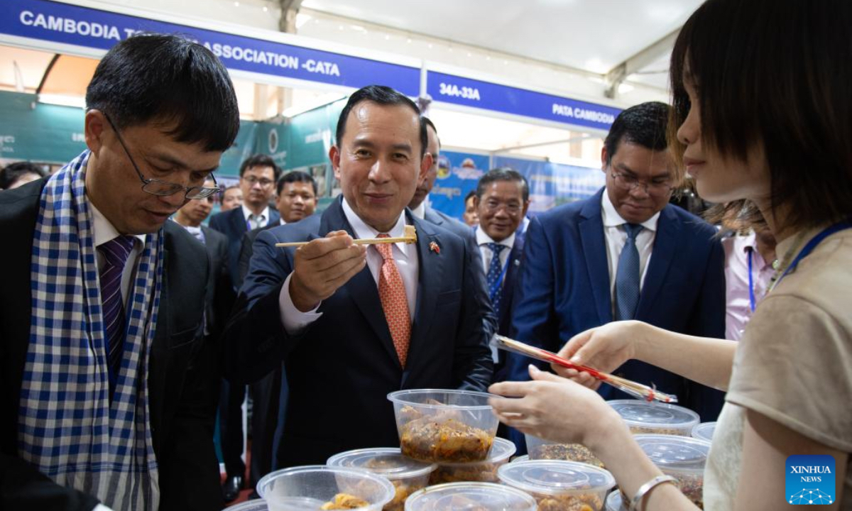 Cambodian Minister of Tourism Huot Hak (C) tastes a Chinese dish during the Cambodia-China Gastronomy Week in Siem Reap province, Cambodia on Oct. 26, 2024. A two-day Cambodia-China Gastronomy Week kicked off here in northwest Cambodia's Siem Reap province on Saturday, attracting food lovers. (Photo: Xinhua)