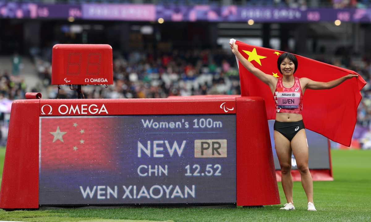 Gold medalist Wen Xiaoyan of China poses for a photo beside the scoreboard after setting a personal best time of 12:52 following the women's 100m T37 final at the Paris 2024 Summer Paralympic Games at Stade de France on September 5, 2024 in Paris.  Photo: VCG