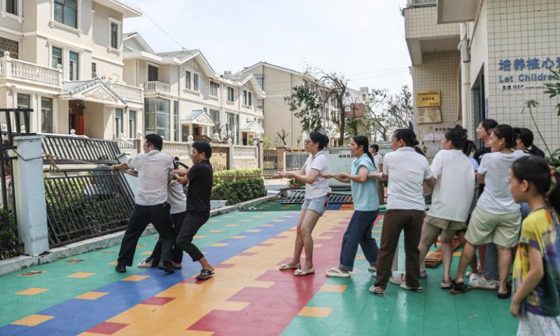 Teachers pull up a leaning fence at a kindergarten in Haikou, south China's Hainan Province, Sept. 8, 2024. Yagi, the 11th typhoon of the year, made landfall in Hainan on Friday afternoon. As winds and rainfall subsided, Hainan downgraded its typhoon alert and initiated swift recovery operations across the province. (Xinhua/Zhang Liyun)