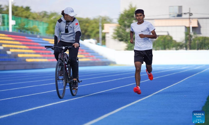 Assistant coach Aisajan Tursun (L) of a local middle and long-distance running team guides runner Abdusalam Abderxit during a training session at a local stadium in Wenquan County in the Mongolian Autonomous Prefecture of Bortala, northwest China's Xinjiang Uygur Autonomous Region, Aug. 30, 2024. The team belongs to the Xinjiang disabled middle and long-distance running training base in the support of disabled persons federations at all levels. (Photo: Xinhua)