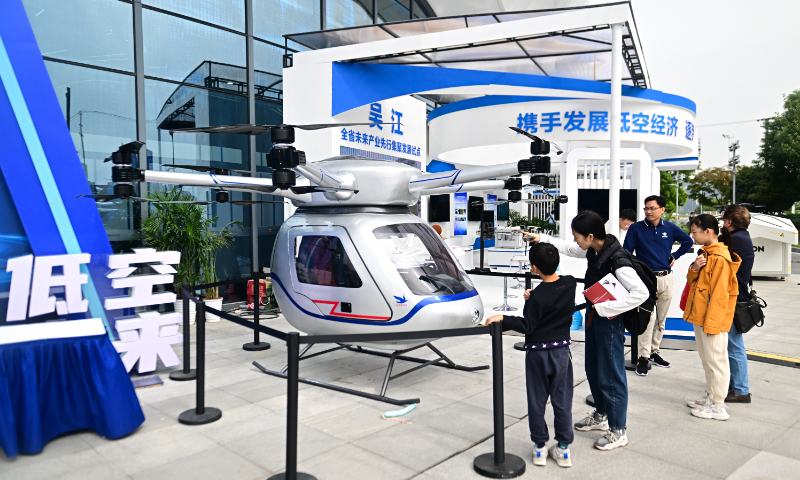 Attendees look at a model of a low-altitude aircraft at the second National Low-Altitude Economy (Suzhou) Industry Innovation Expo in Suzhou, East China's Jiangsu Province on October 20, 2024. China's low-altitude economy exceeded 500 billion yuan ($70.4 billion) in 2023, and it is expected to reach 3.5 trillion yuan in 2035, according to data from CCID Consulting. Photo: VCG