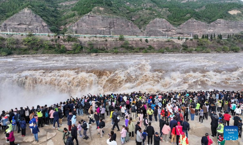 Tourists visit the Hukou Waterfall on the Yellow River, on the border area between north China's Shanxi and northwest China's Shaanxi provinces, on Oct. 4, 2024. (Xinhua/Chen Yehua)