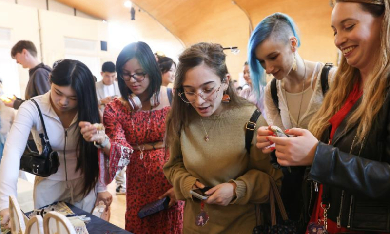 People visit market stalls during a Hanfu display event held to celebrate the upcoming Mid-Autumn Festival in London, Britain, Sept. 8, 2024. (Xinhua)