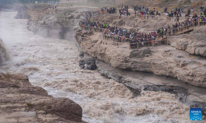 Tourists visit the Hukou Waterfall on the Yellow River, on the border area between north China's Shanxi and northwest China's Shaanxi provinces, on Oct. 4, 2024. (Xinhua/Chen Yehua)