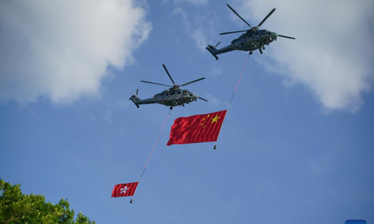 Helicopters carrying the Chinese national flag and the Hong Kong Special Administrative Region (HKSAR) flag fly over Victoria Harbor during a ceremony held to celebrate the 75th anniversary of the founding of the People's Republic of China in Hong Kong, south China, Oct 1, 2024. Photo:Xinhua