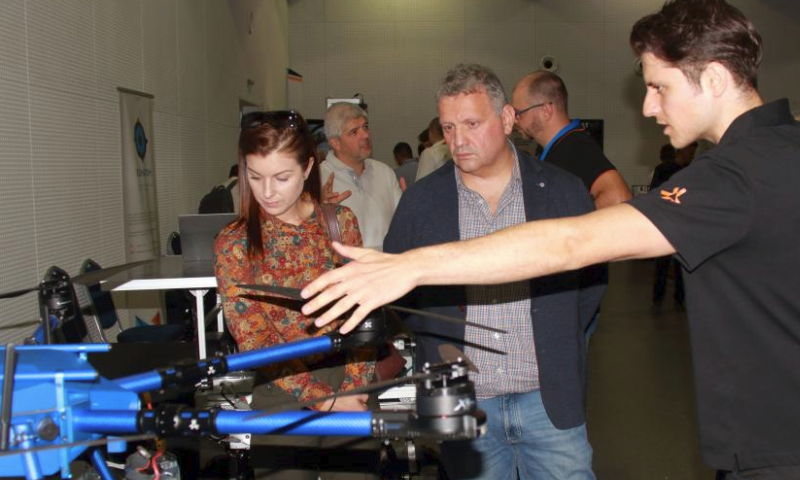 People visit the exhibition area of the Robotics Strategy Forum 2024 in Sofia, Bulgaria, on Sept. 26, 2024. The event was held on Thursday at Sofia Tech Park for the sixth consecutive year, continuing its mission to boost innovation in robotics and autonomous technologies. (Photo by Marian Draganov/Xinhua)