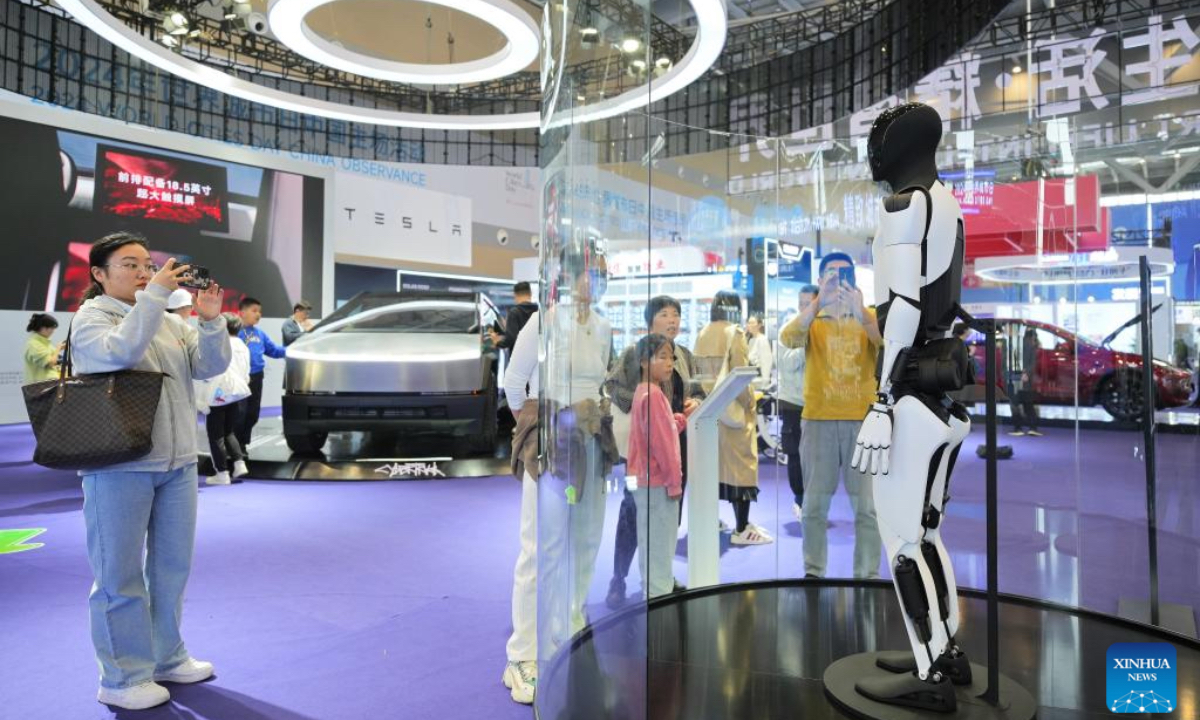 People look at a robot of Tesla at an exhibition of the 2024 World Cities Day China Observance in Weihai, east China's Shandong Province, Oct. 26, 2024. More than 2000 delegates from over 30 countries and regions attended the event. (Photo: Xinhua)